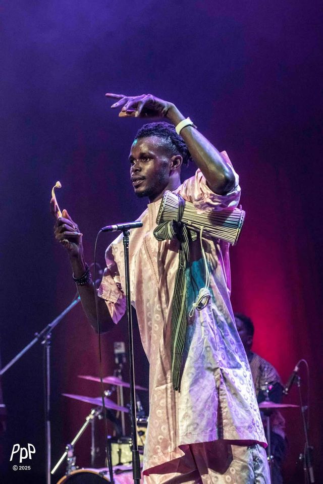 Un danseur du groupe, bras levés, pendant un concert de Zale Seck.