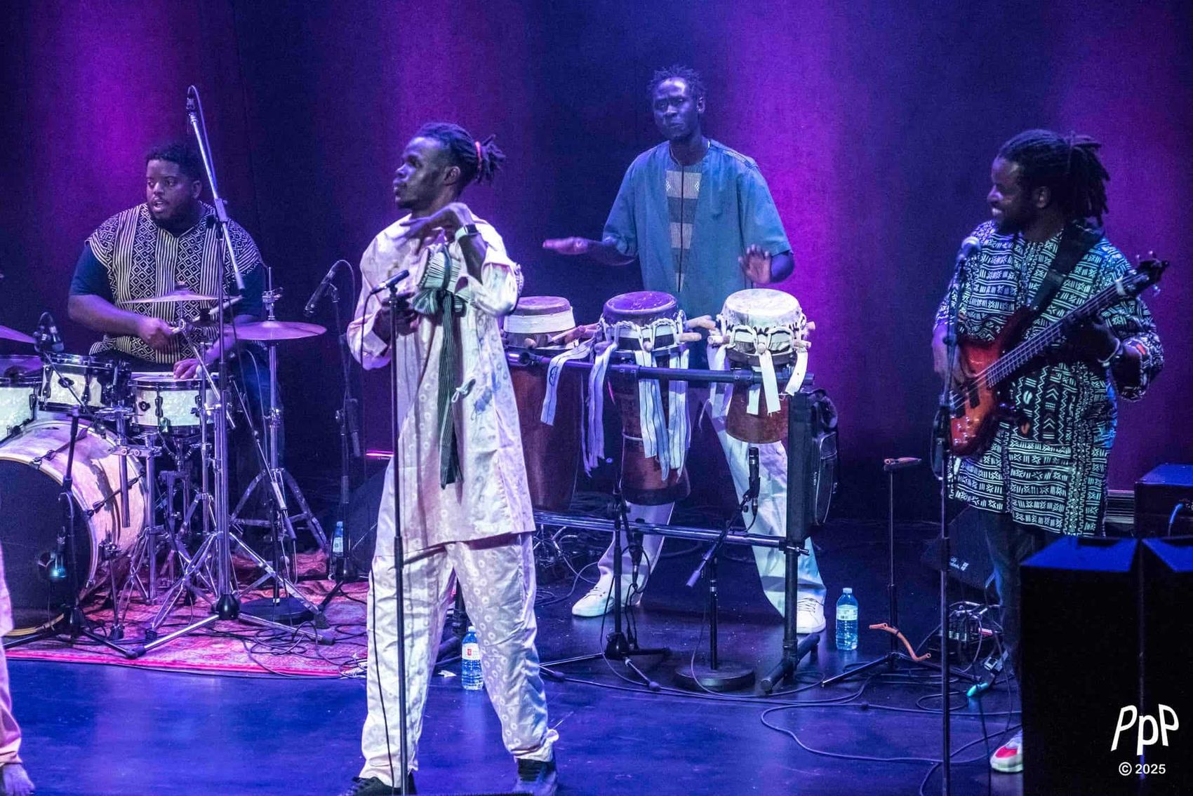 Zale Seck et ses musiciens sur scène : batterie, percussions et basse.