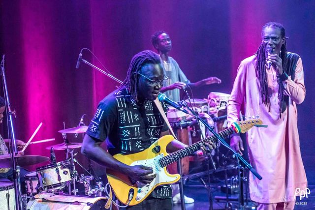 Le guitariste du groupe au premier plan, Zale Seck au micro à droite.